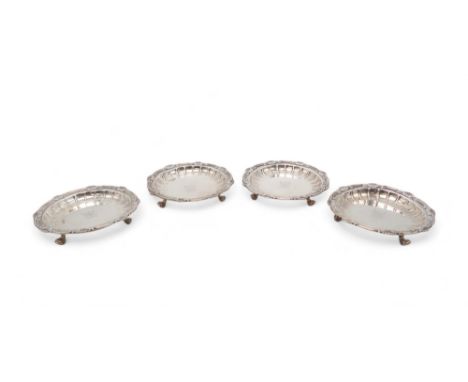 A SET OF FOUR GEORGE V SILVER DISHES by Crichton Brothers, London 1930, of circular form, with cast scrolling shellwork rims,