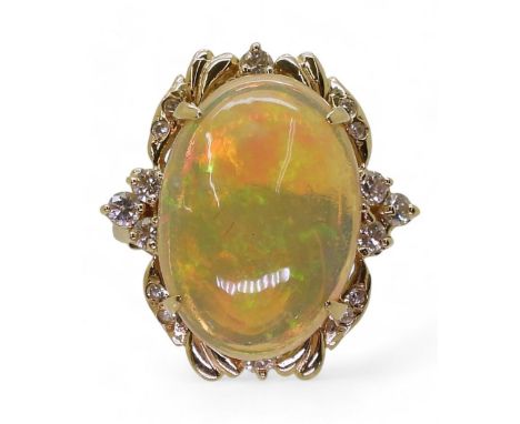 AN OPAL STATEMENT RING set with a 18.5mm x 13mm x 5.6mm cabochon jelly opal, the 14k gold mount is further enhanced with bril