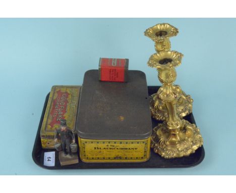 A pair of gilded candlesticks together with three collectors advertising tins and a vintage cast metal 'Hummel Hummel Mors-Mo