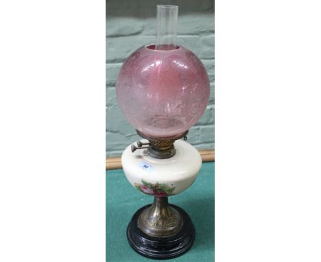 An antique oil lamp with pottery reserve and cranberry to clear glass shade (age related wear)