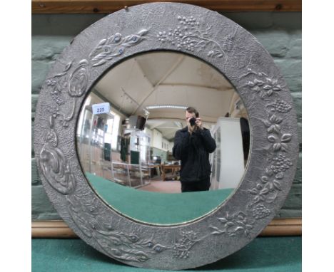 A vintage pewter framed round convex mirror decorated with a peacock set with glass cabochons in the tail, 59cm diameter