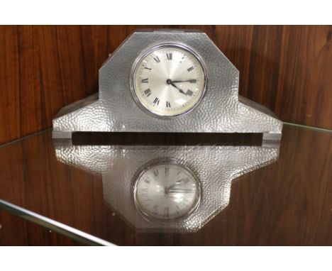 AN ARTS AND CRAFTS STYLE HAMMERED EFFECT PEWTER CASED MANTEL CLOCK