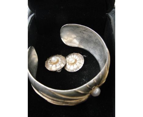 A silver bangle with gilt starburst pattern and pearl, with matching earrings