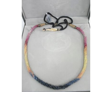 A ruby and sapphire nine-strand necklace: with cased ruby & sapphire beads strung and twisted in a rope design