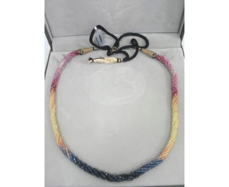 A ruby and sapphire nine-strand necklace: with cased ruby & sapphire beads strung and twisted in a rope design