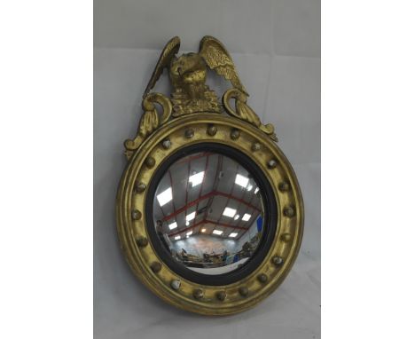 A Regency circular gilt mirror with eagle to finial