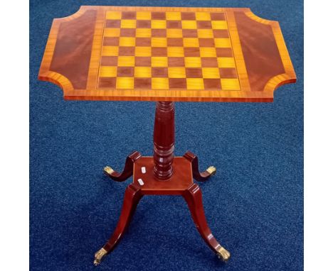 A reproduction mahogany elegant games table, on brass castors, inlaid chess/draughts board to surface, height 69cm.