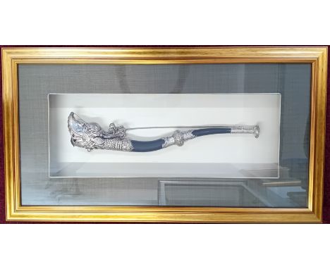 A Tibetan trumpet with dragon motif, together with a ceremonial dagger, both framed and glazed. (2)