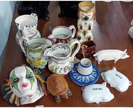 A Staffordshire dog pitcher, together with four jugs, a match striker, a pig, small boot, and other pieces. (12)