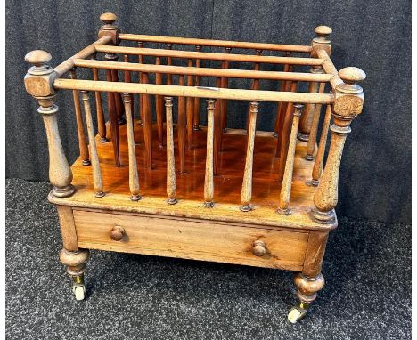 19th century mahogany magazine rack with 3 compartments above a singular drawer raised on turned legs ending in ceramic casto