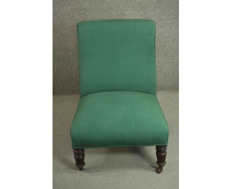 A Victorian mahogany nursing chair, upholstered in green fabric, on ring turned legs. H.85 W.61 D.67cm. 