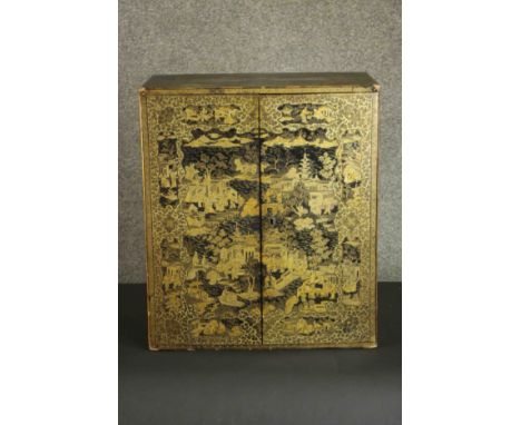 A 19th century Chinese gilt and lacquered table top cabinet with all over hand painted decoration showing figures in garden s