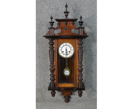 A late 19th century walnut cased Vienna regulator with Roman numerals on a white enamel dial. The pendulum with RA monogram o