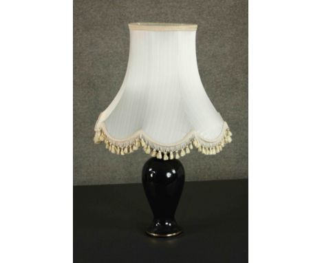 A late 20th century black glazed ceramic baluster form table lamp, with a cream coloured shade. H.75 W.45cm. 