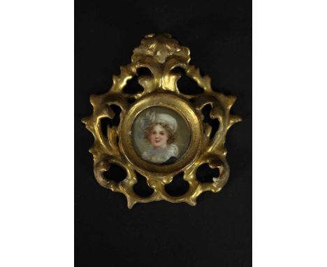 A pierced and carved giltwood framed hand painted miniature portrait on porcelain of a young lady, indistinctly signed. H.25 