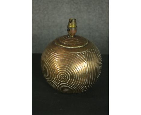 A brass table lamp, of spherical form and decorated with concentric circles. H.25 Dia.20cm. 