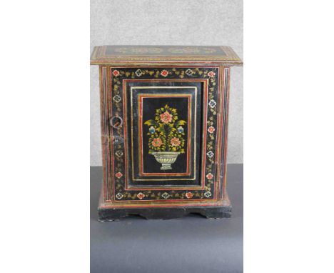 An Indian painted cupboard, the rectangular top over a single cupboard door with an iron ring handle, on a shaped plinth base