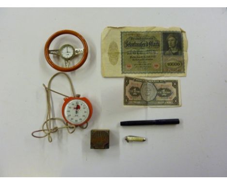 A tray containing a novelty clock in the form of a steering wheel; a Mabie Todd and Co. Blackbird fountain pen; a shell stamp