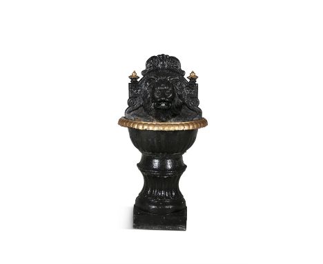 A VICTORIAN CAST IRON WATER FOUNTAIN, the domed backplate with lion mask, flanked with parcel gilt torches, floral motifs and