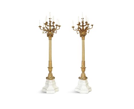 A PAIR OF 19TH CENTURY MONUMENTAL STANDING PALACE CANDELABRA, the gilt metal twelve light scrollwork candleholders raised on 