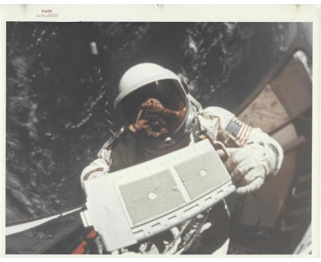 James LovellBuzz Aldrin, photographed in the open hatch, carries a micrometeoroid package to the spacecraft during an EVAGemi