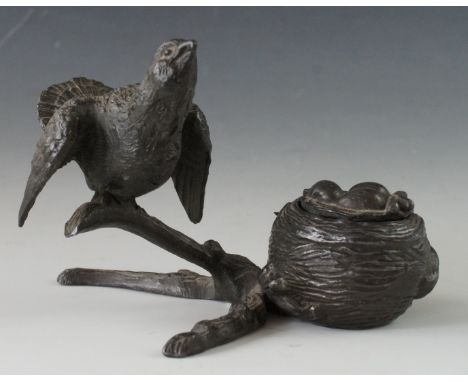 A Victorian novelty inkwell modelled in the form of a bird and nest on a gnarled bough, the next containing a clutch of eggs 