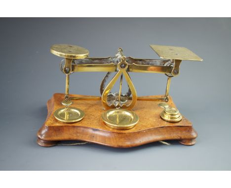 A set of Victorian brass postal scales and weights on a walnut base, 21 x 12 x 21 cm high