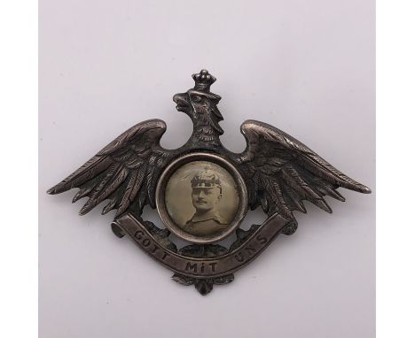 An Imperial German white metal (tested as silver) patriotic brooch in the form of an Imperial eagle holding a scroll with leg