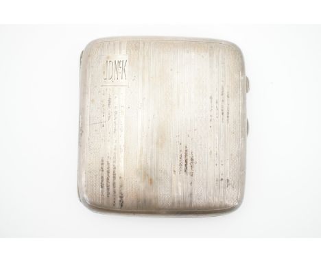 A silver cigarette case, with banded and engine-turned decoration surrounding a square cartouche and the initials 'J.D.McK', 