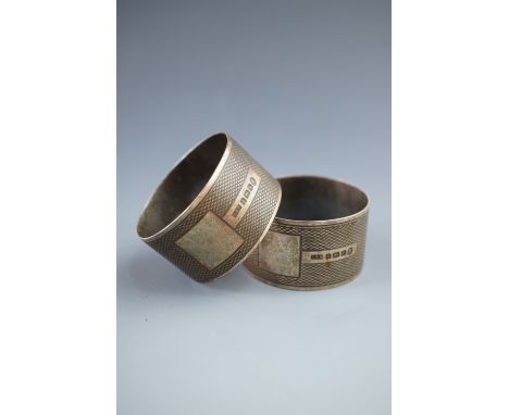 A pair of George V silver napkin rings, each with engine turned decoration and a vacant cartouche, Birmingham, 1934, 44.5g