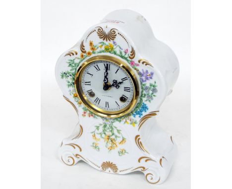 German pottery two train mantel clock striking on a bell, the 3.5" white dial within a balloon shaped case painted with flowe