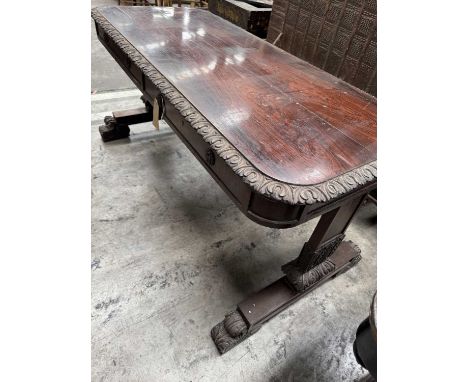 EARLY 19TH C. ROSEWOOD LIBRARY TABLE, leaf carved moulded edge above two drawers on each side, foliate carved trestle end, ta