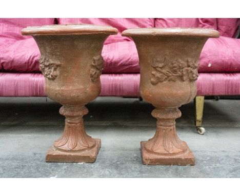 PAIR OF PAINTED TERRACOTTA URNS with moulded decoration and leaf moulded socle bases, 57cms (h) (2)Provenance: The Cornelia B