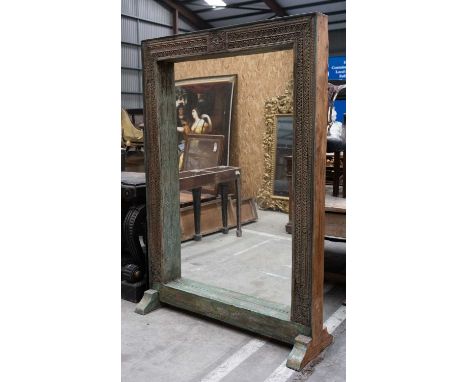 INDIAN CARVED TEAK ARCHITECTURAL STANDING MIRROR, carved foliate frame on sleigh feet, foliate painted detail, 202 x 140cmsCo