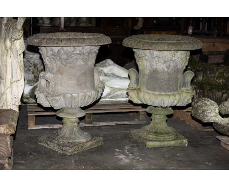 LARGE PAIR OF RECONSTITUTED STONE URNS, everted rims above grape vine ornament, gadrooned bases, and mask headed loop handles