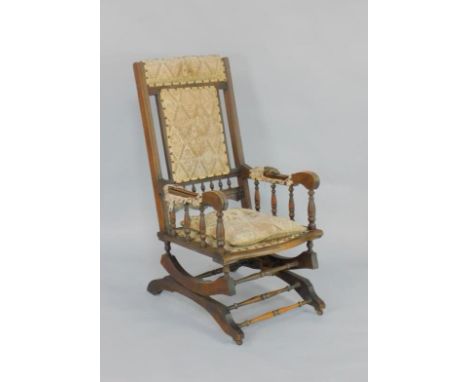 An American late 19thC beech rocking chair, with studded tapestry seat and back.