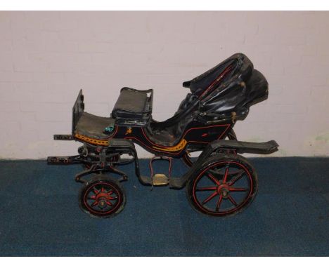 A Victorian child's barouche carriage, the coachwork painted in black, yellow and red, with a folding hood, button leather se