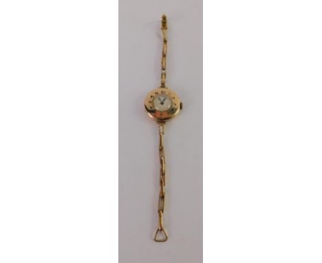 A lady's 9ct gold half hunting cased wristwatch, casing bearing Arabic blue enamel numerals, on a yellow metal strap, marked 