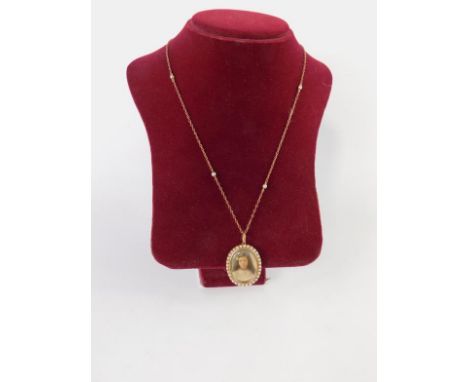 An Edwardian oval pendant photo locket, in a surround of seed pearls, on a chain, the portrait purported to be of Miss Isabel