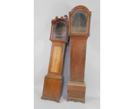 Two George III longcase clock cases, one plain oak, 212cm high, the other with a mahogany hood and cross banding to the trunk