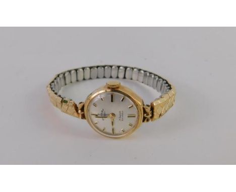 A Rotary lady's 9ct gold circular cased wristwatch, silvered dial, on a plated expanding bracelet.
