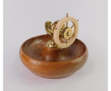 A 1930's capstan form nut cracker, brass and cream Bakelite set within a mahogany bowl, 17.5cm diameter.