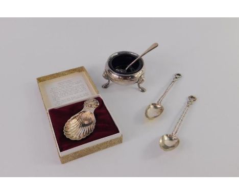A silver circular salt raised on three hoof feet, with blue glass liners, and silver spoon, London 1982, silver shell caddy s