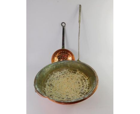 A Victorian copper colander with brass hanging loop, 39.5cm diameter, a copper sieve with iron handle, 42cm long, and a brass
