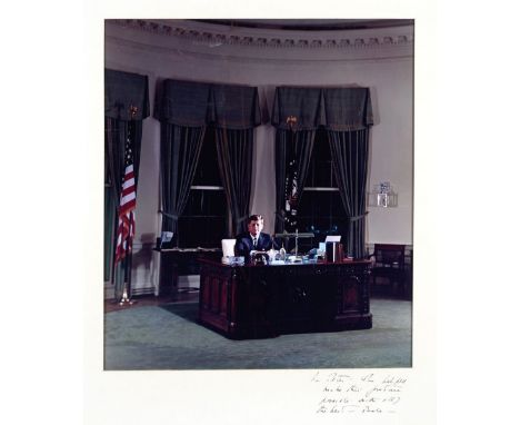 KENNEDY (JOHN F.)Colour portrait photograph depicting John F. Kennedy sitting behind the Resolute desk in the Oval Office,  b