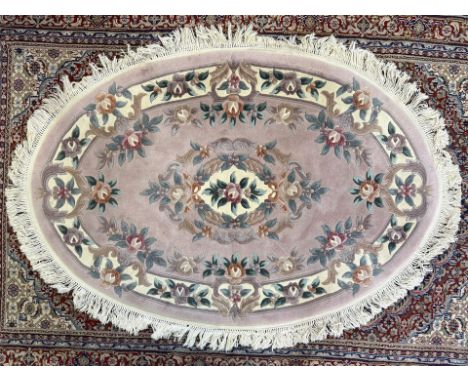 Persian Style Rug, oval style with deep fringing, pink ground with cream and floral pattern and deep cream fringe.  Measures 