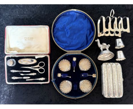 Small Collection Of Silver - To include a 4 slice toast rack, a damaged cruet set in the form of a camel, a vanity set and a 