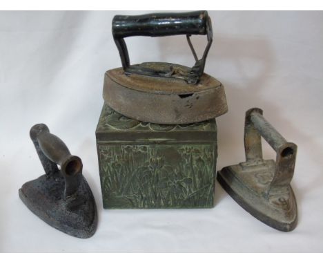3 Flat irons and a lead tea caddy with dragon decorated lid