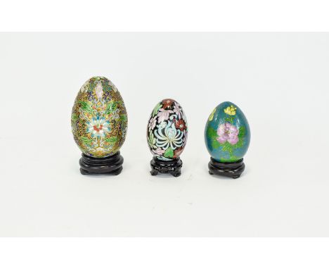 Chinese Cloisonne Eggs Three in total in descending size, the largest with interlocking scroll and foliate design on gold gro