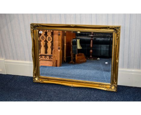 Bevelled Glass Mirror Wall mounted in rectangular classical style yellow gilt frame. Approx dimensions 41 inches in width, 29